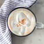 overhead view gingerbread latter in a clear mug next to a napkin