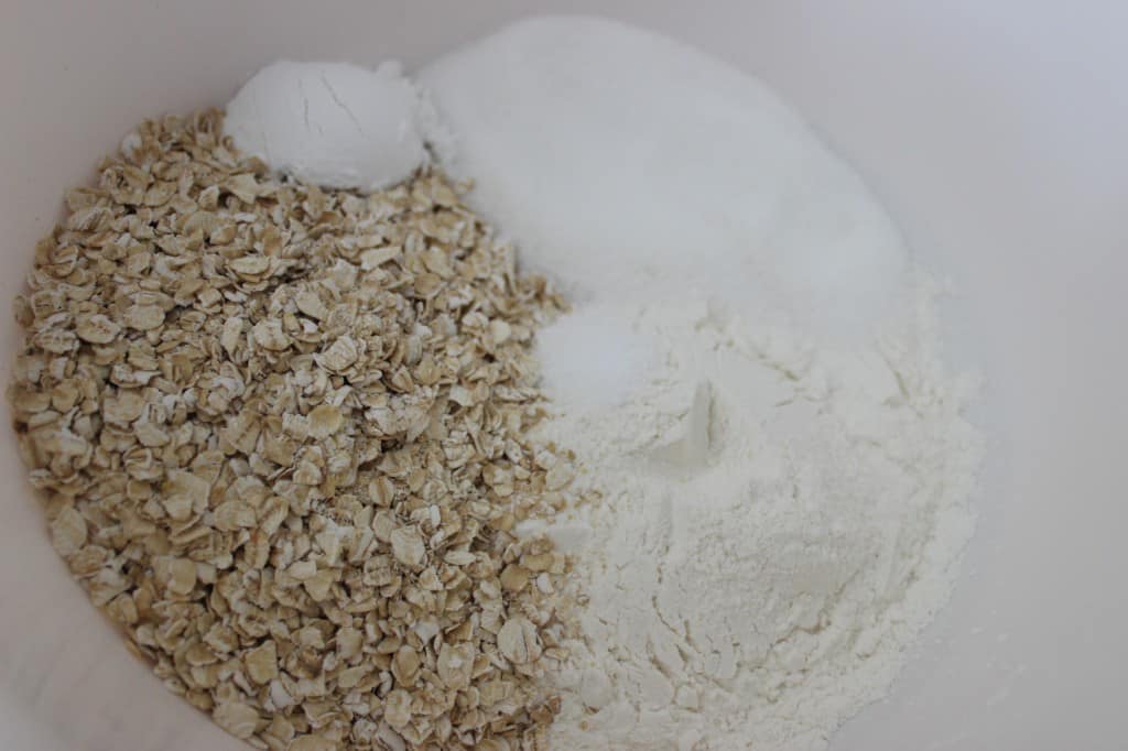 flour, oatmeal, baking powder, salt, and sugar in white mixing bowl 