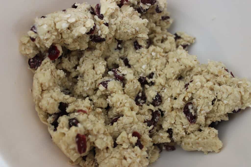dried cherries added to oat scone mixture in white bowl 