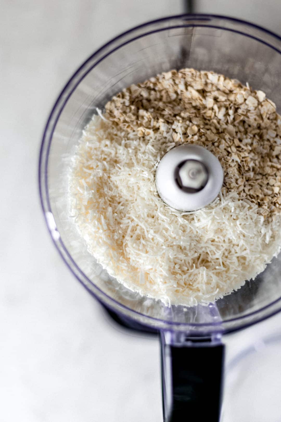 food processor with oatmeal and coconut in it