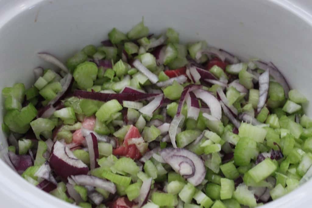 celery and onion added on top of beef in slow cooker 