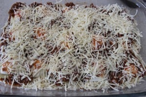 Cheese added to the other layers in a glass dish.