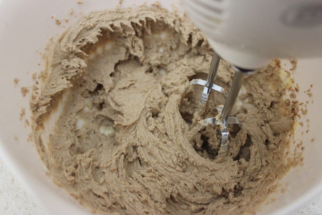 cookie batter in white bowl with hand mixer 