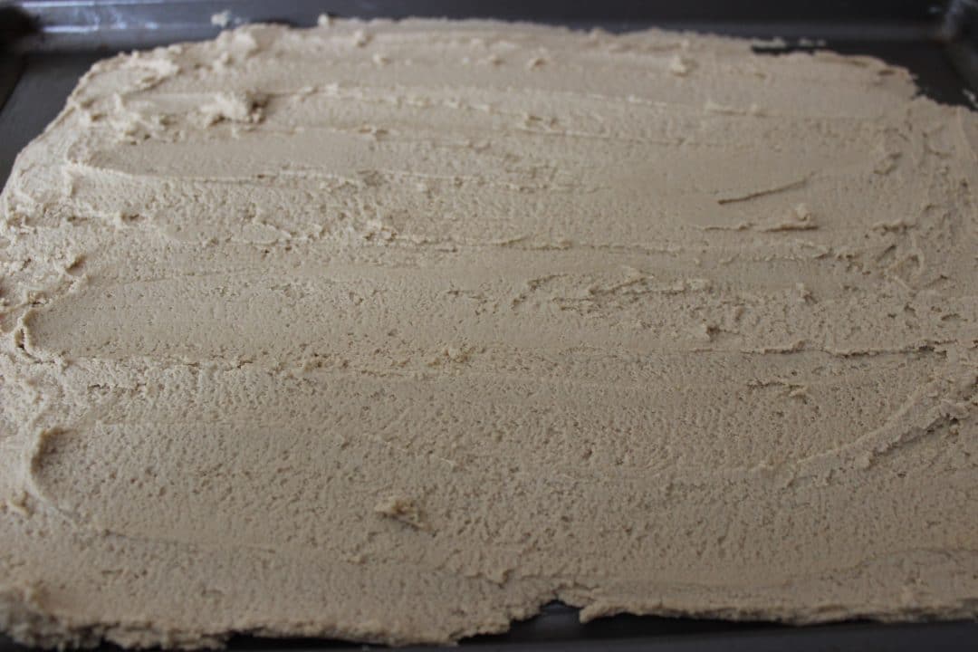 cookie batter spread on baking sheet 