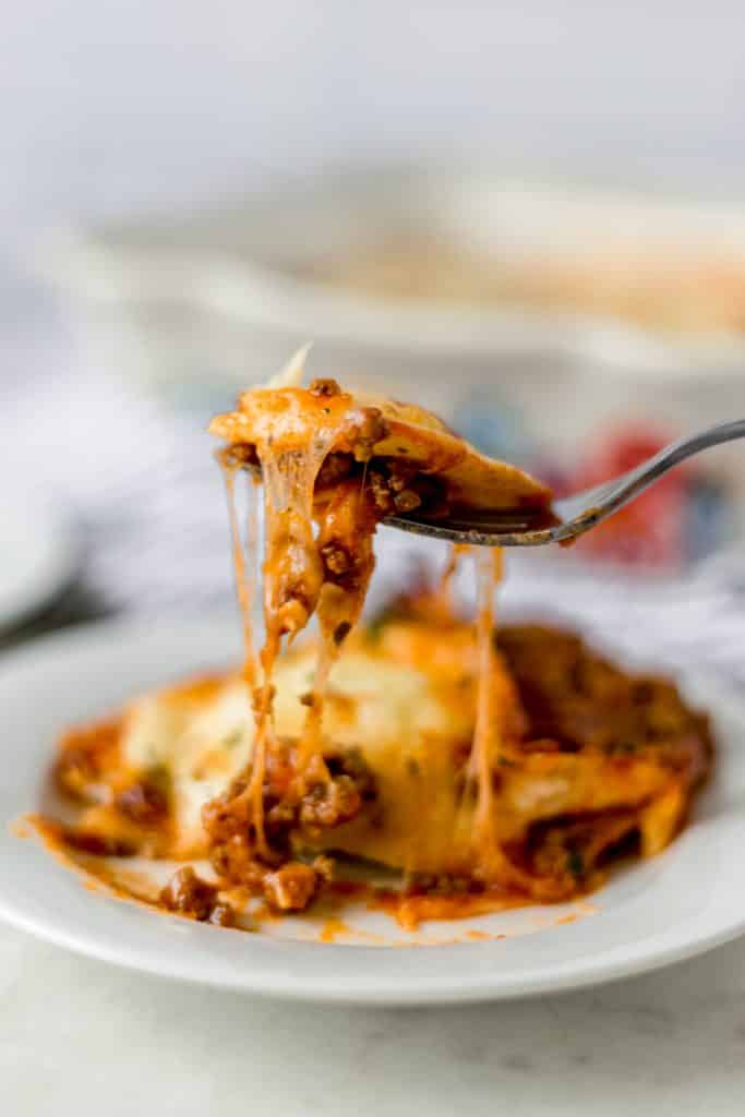 close-up side shot of cheesy ravioli lasagna with fork 