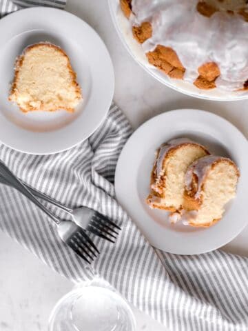 overhead view of slices of cake on white plates with the rest of the pound cake in the background