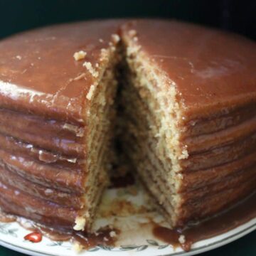 close up front view of chocolate cake with slice cut out of it