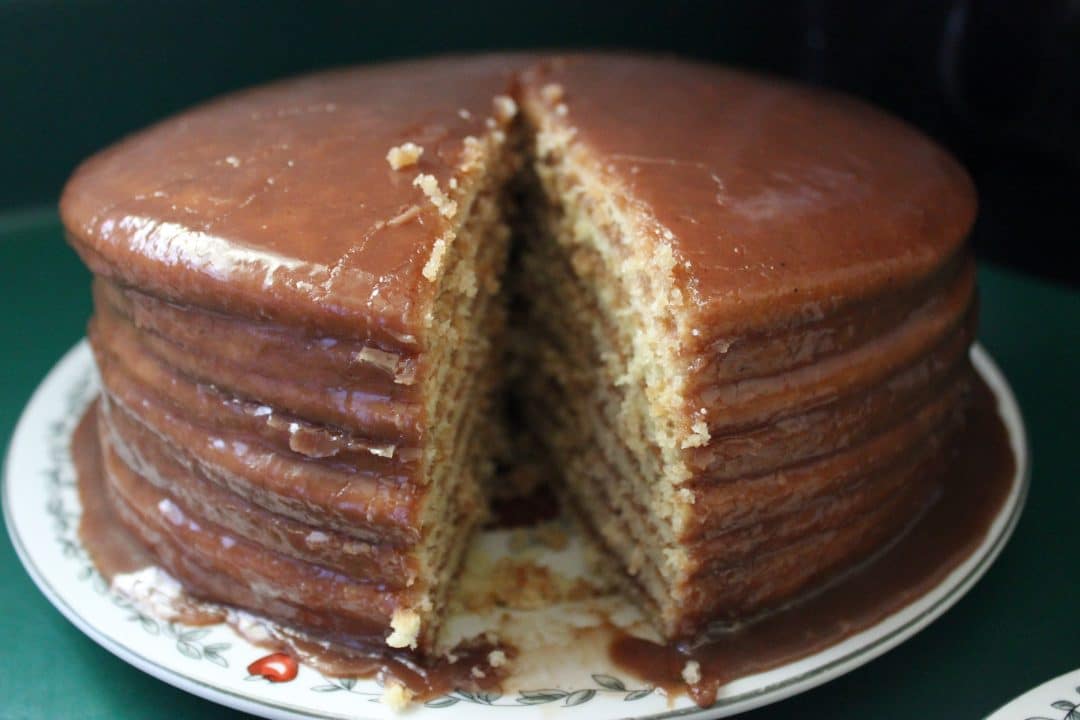close up front view of chocolate cake with slice cut out of it