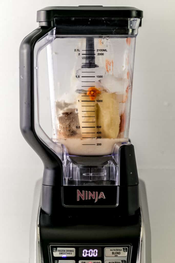 ingredients for pumpkin spice smoothie added into a blender.