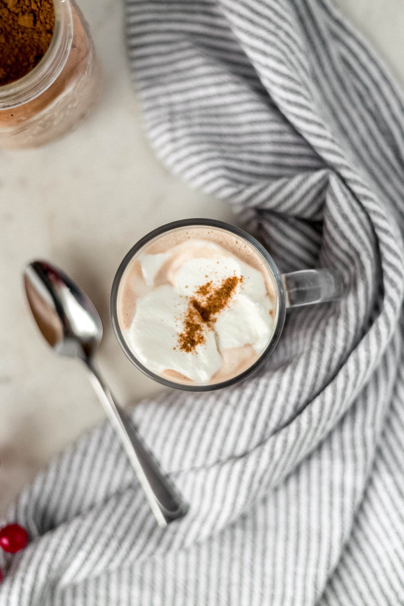 overhead view of cup of hot chocolate with spoon and napkin