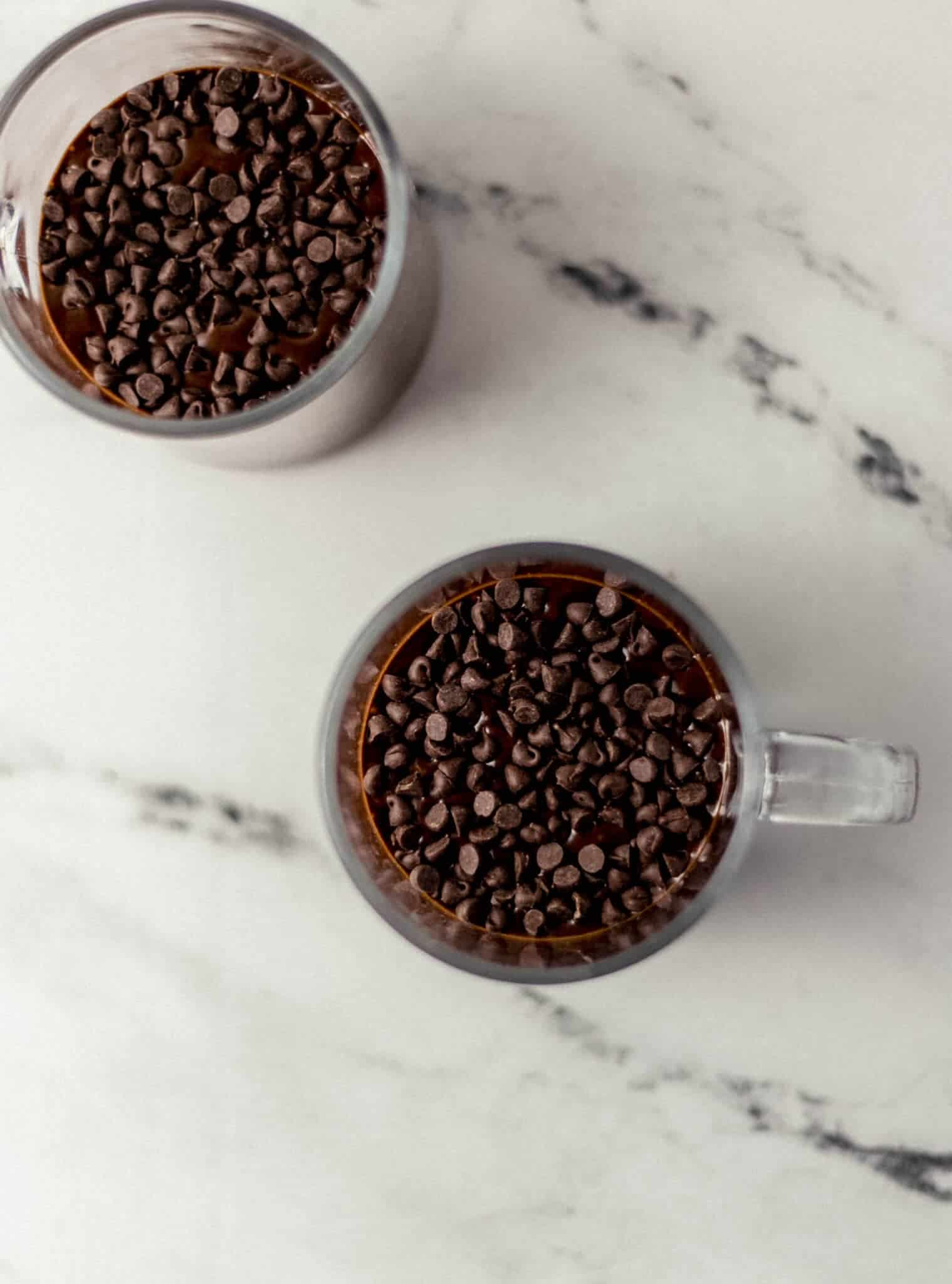 cake mix in glasses topped with chocolate chips before baking