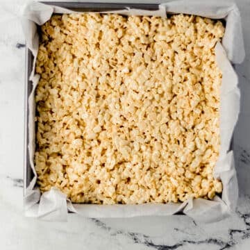 rice crispy treats pressed into parchment lined baking pan