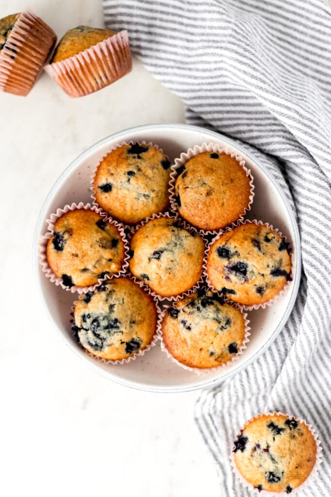 batch of blueberry muffins in a large bowl over a napkin