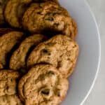 white plate with a batch of chocolate chip cookies on it