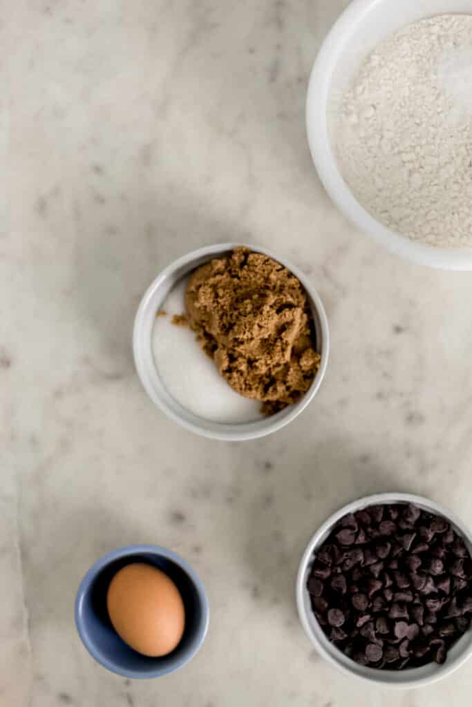 ingredients for chocolate chip cookies in small bowls 
