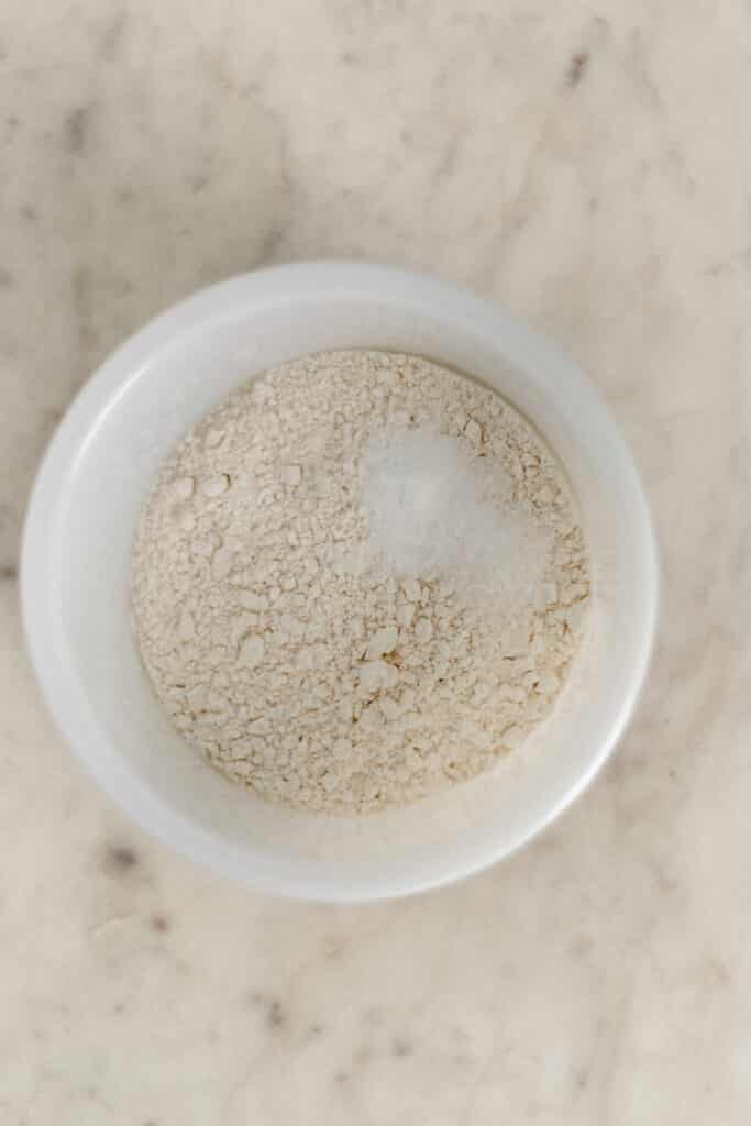 small white mixing bowl with flour, baking soda, and salt