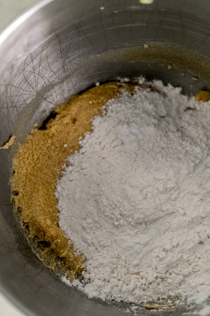 flour mixture added to cookie mixture in stand mixer bowl