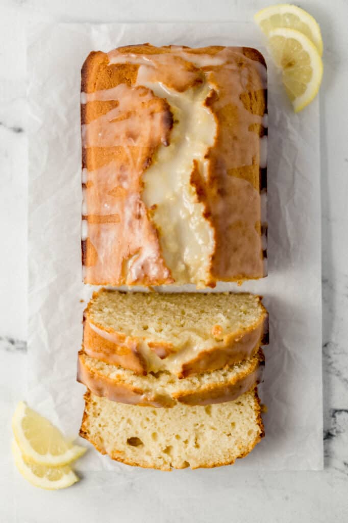 overhead view of sliced bread on parchment paper with lemon slices