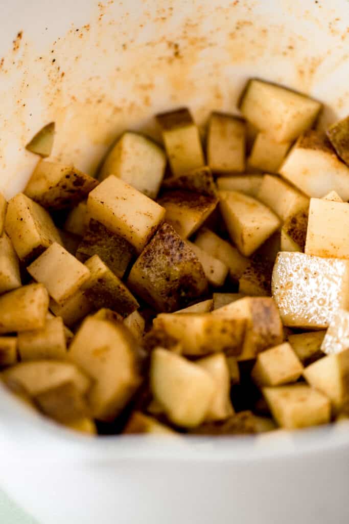 potatoes in large mixing bowl tossed in olive oil and seasonings