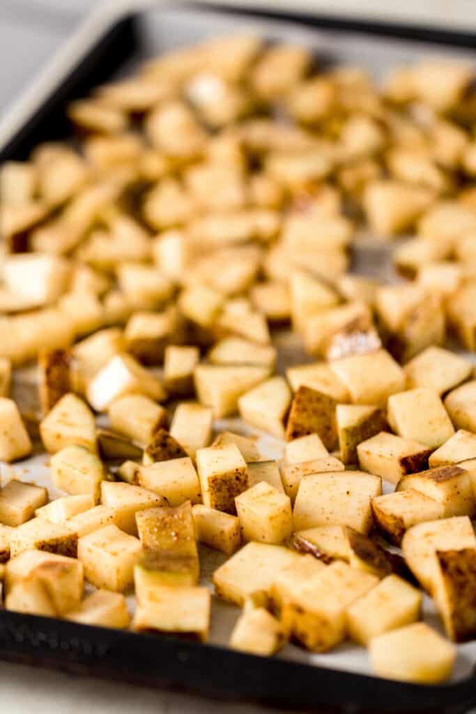 uncooked diced potatoes on parchment-lined baking sheet