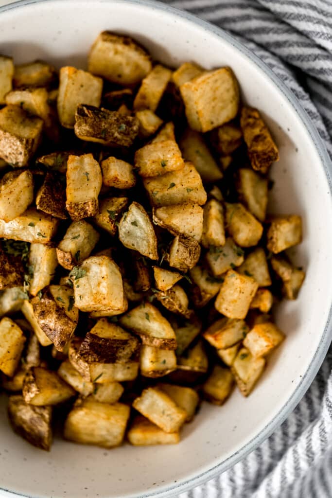 oven roasted potatoes in large serving bowl next to a napkin