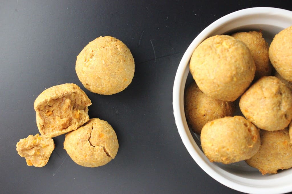 overhead view of dog treats in white bowl on black surface 