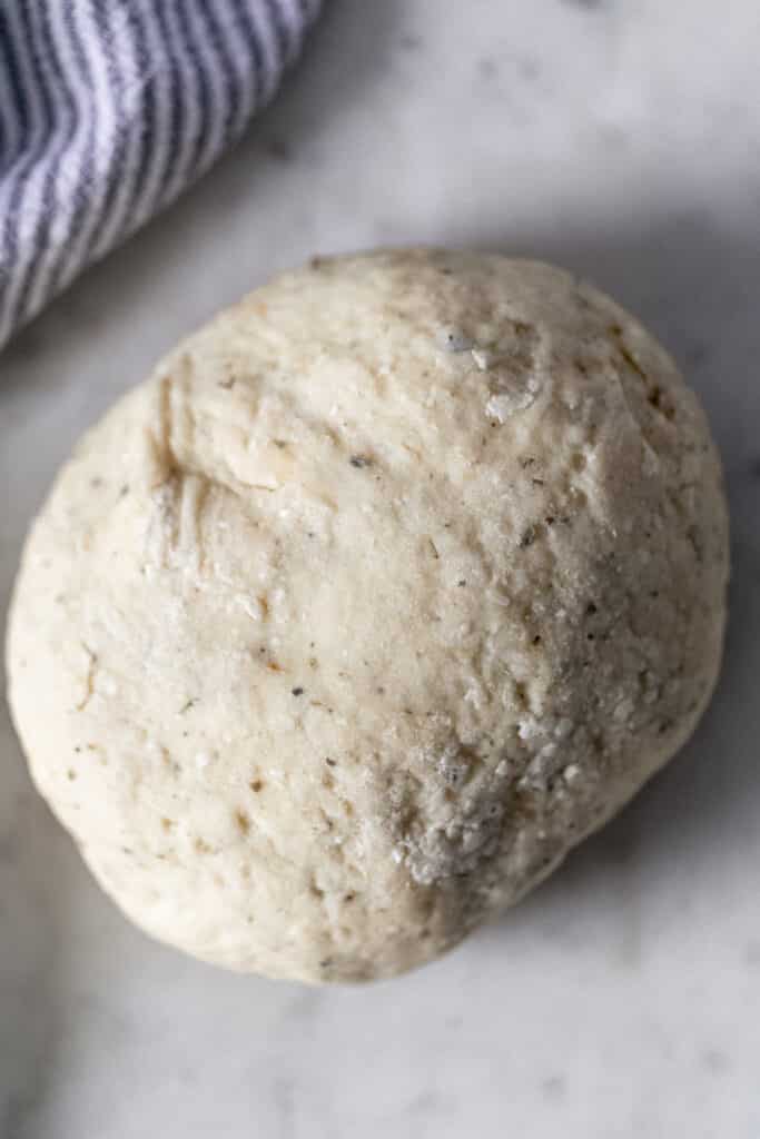 overhead view of homemade pizza crust on counter with napkin