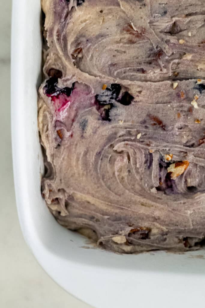blueberry coffee cake mixture spread evenly in white square baking dish 