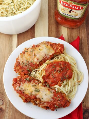overhead view baked chicken mozzarella and cooked spaghetti in a bowl