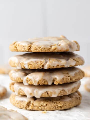 close up side view stack of iced oatmeal cookies