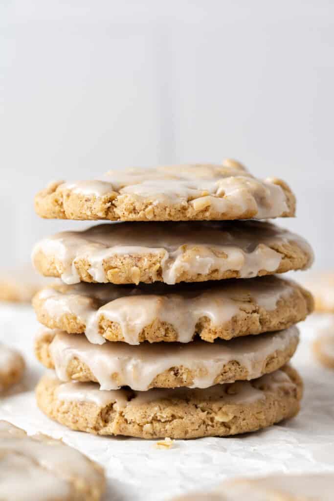 close up side view stack of iced oatmeal cookies