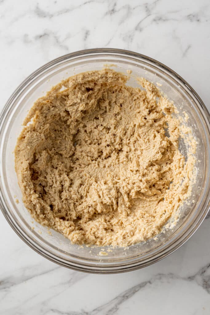 ingredients to make oatmeal cookies in glass mixing bowl 