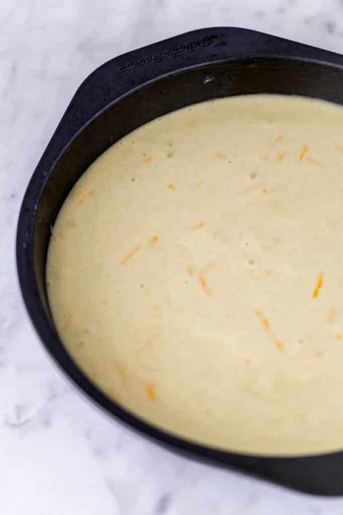 olive oil cake mixture poured into a round baking pan 
