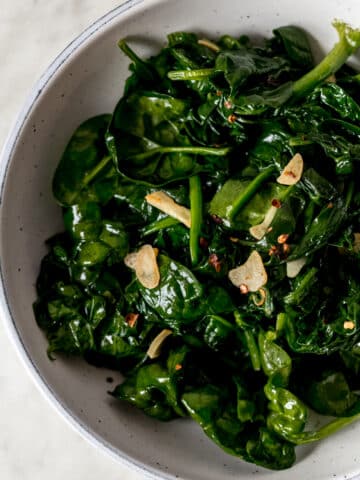 overhead view of sauteed garlic spinach in a large bowl