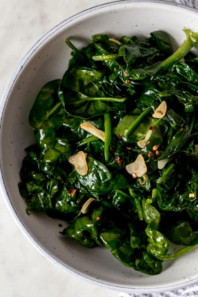 overhead view of sauteed garlic spinach in a large bowl