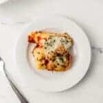 serving of stuffed shells on white plate with a fork.