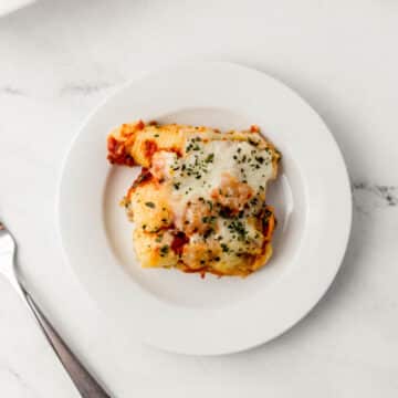 serving of stuffed shells on white plate with a fork.