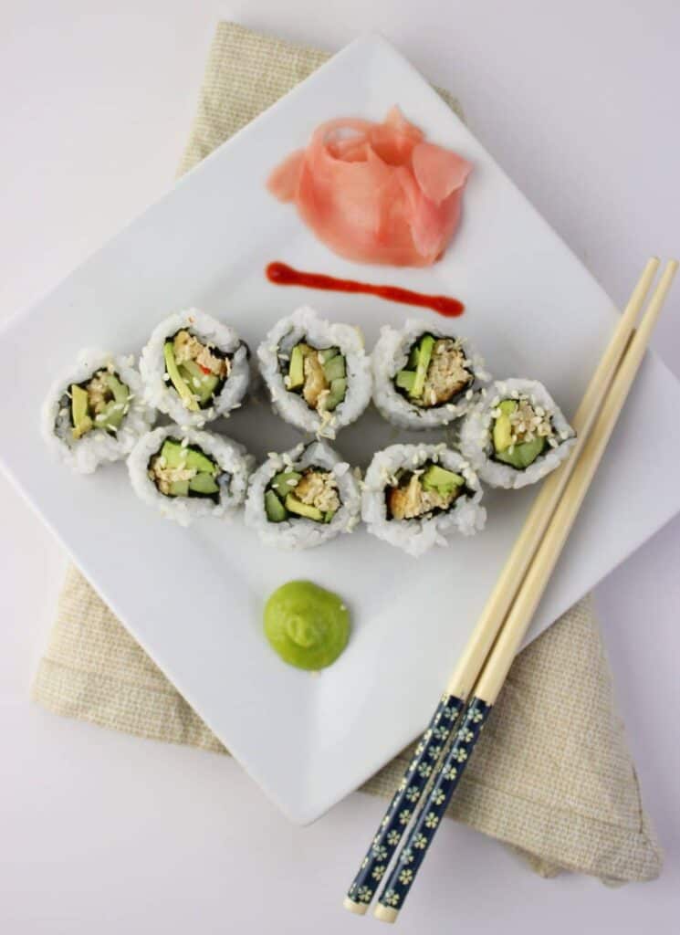 overhead view of finished sushi on white square plate 