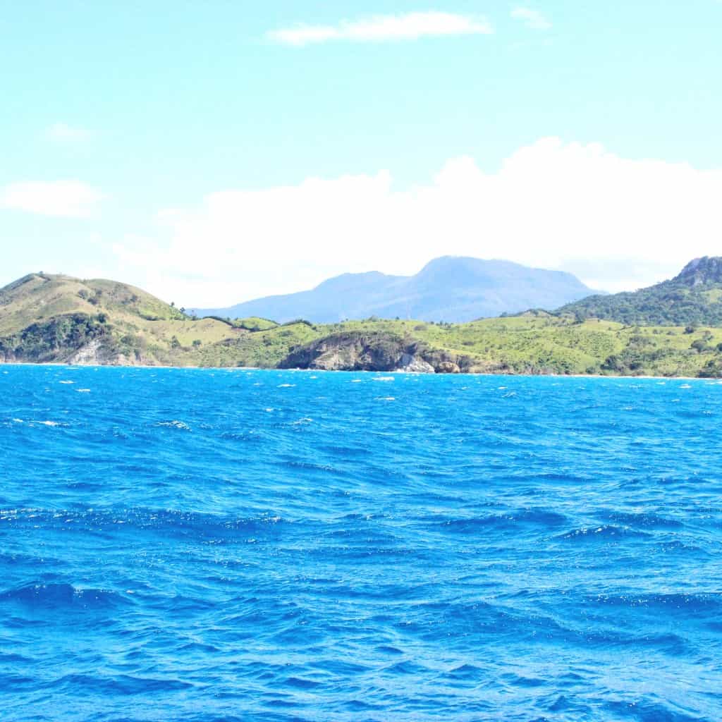 caribbean water and sky with mountains in the background 