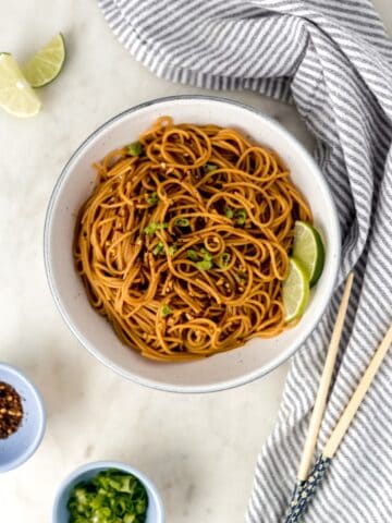 overhead view easy sesame noodles in white bowl with napkin and chop sticks