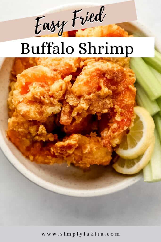 Overhead view of buffalo shrimp in white bowl with celery sticks and lemon slices pin with text overlay.