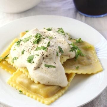 ravioli topped with sauce on white plate