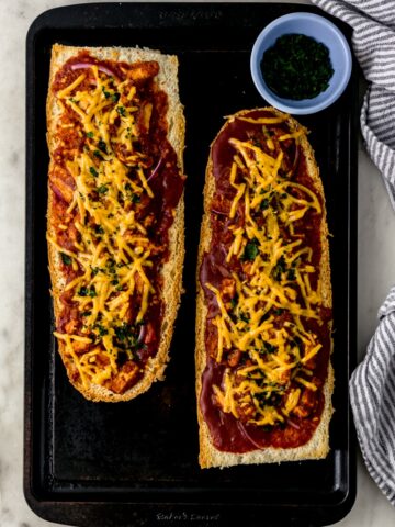 BBQ French bread pizza on baking sheet next to cloth napkin