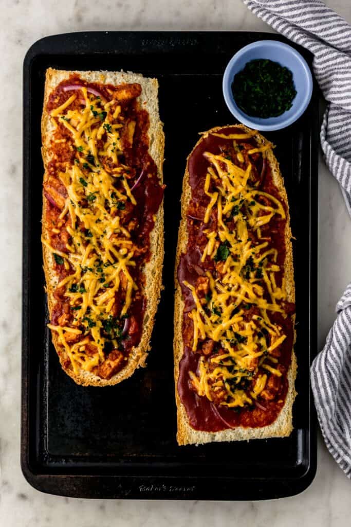 BBQ French bread pizza on baking sheet next to cloth napkin 