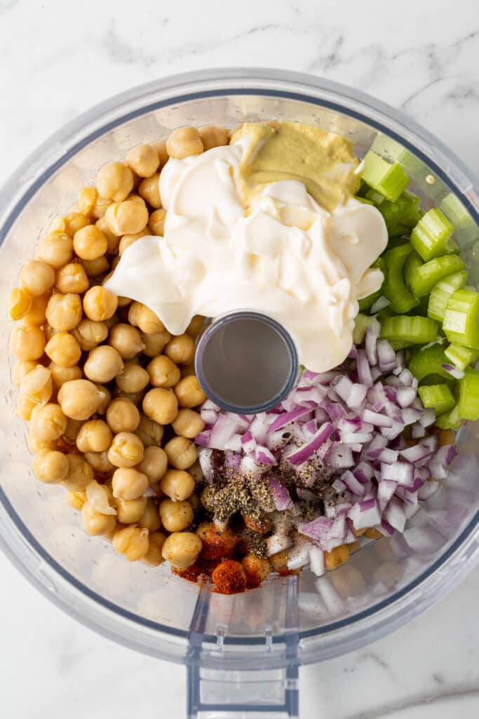 food processor with ingredients to make chickpea salad in it. 