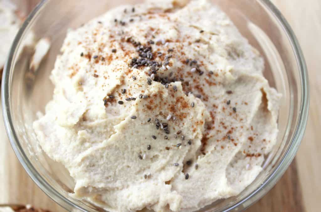 close up view of cashew butter topped with ground cinnamon and chia seeds 