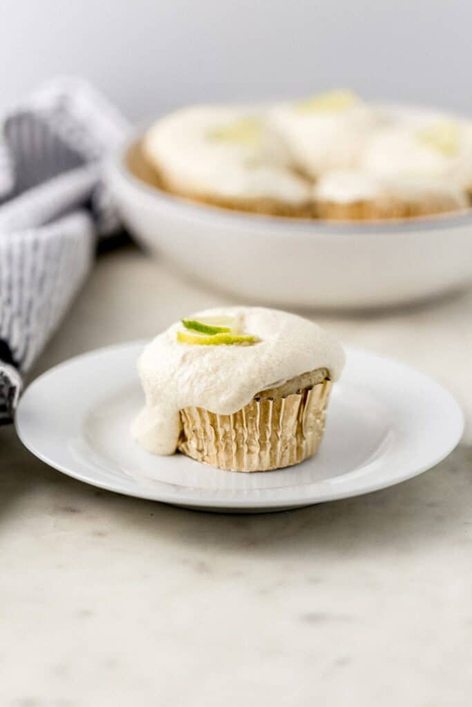 margarita cupcake on small white plate beside cloth napkin with more in the background