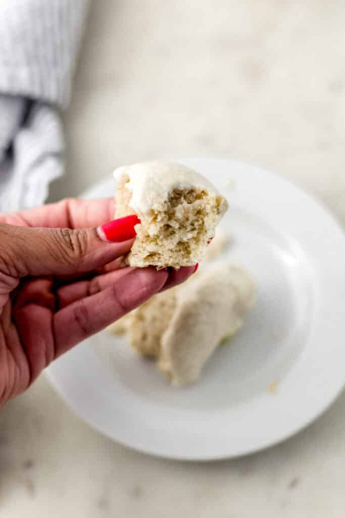 hand holding piece of margarita cupcake over small white plate