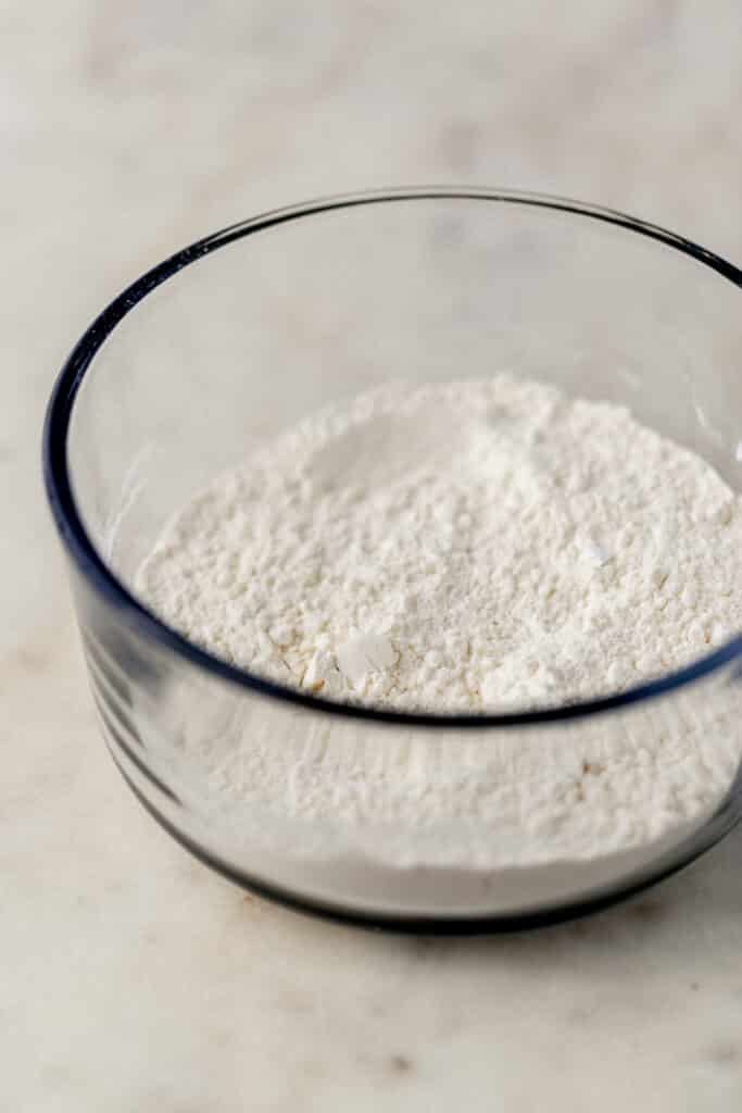 flour mixture in glass bowl on marble surface