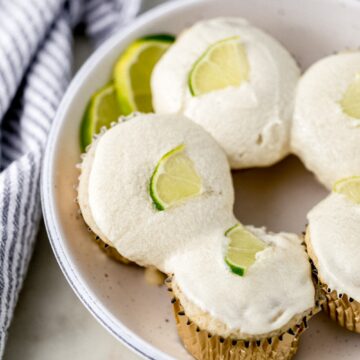 white serving bowl with margarita cupcakes in it next to cloth napkin